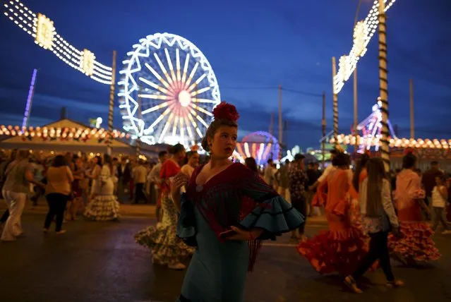 A woman wearing a sevillana dress looks back during the traditional Feria de Abril (April fair) in the Andalusian capital of Seville, southern Spain, April 23, 2015. (Photo by Marcelo del Pozo/Reuters)