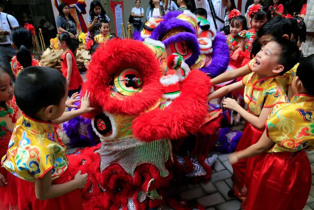 Filipino-Chinese students play with Lion dancers after performing a traditional dance ahead of the Lunar New Year celebrations at the Lucky Chinatown Mall in Binondo city, metro Manila, Philippines January 26, 2017. (Photo by Romeo Ranoco/Reuters)
