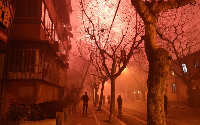 Fireworks explode in a street of Shanghai on the eve of Chinese New Year on January 30, 2014. China prepares to welcome the Lunar New Year of the Horse which falls on January 31 and will see about 3.62 billion trips made by Chinese travelers during the 40-day Spring Festival travel period. (Photo by Peter Parks/AFP Photo)