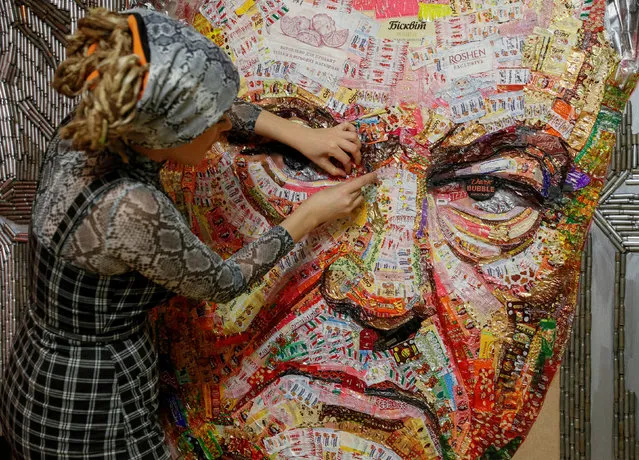 Ukrainian artist Dariya Marchenko works on a portrait of Ukraine's President Petro Poroshenko named 'The Face of Corruption' which is made of wrappers from more than 20 kilograms of Roshen candies and empty shell cartridges brought from the frontline of a military conflict in the east of the country, in Kiev, Ukraine March 27, 2019. (Photo by Valentyn Ogirenko/Reuters)