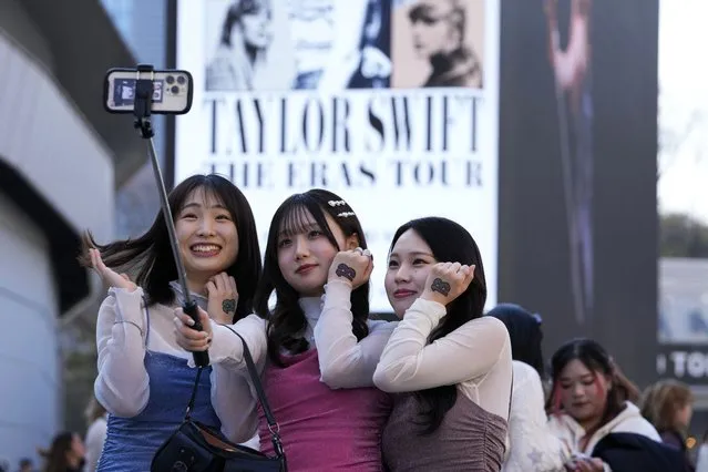 Women pose for a selfie before Taylor Swift's concert at Tokyo Dome in Tokyo, Saturday, February 10, 2024. (Photo by Hiro Komae/AP Photo)