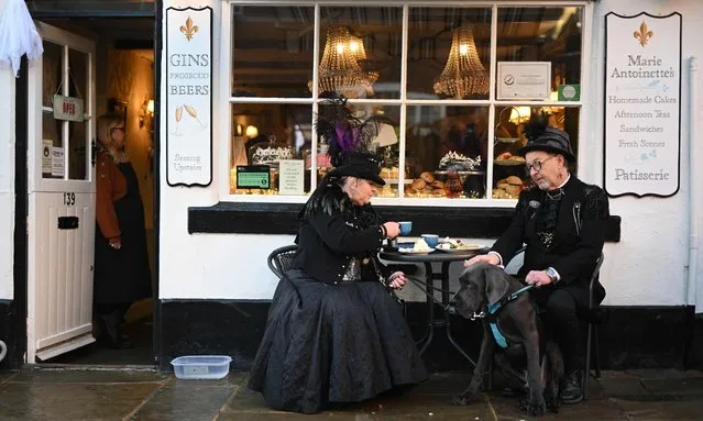 Participants in costume stop for a cup of tea in the town during the biannual “Whitby Goth Weekend” festival in Whitby, northern England, on October 31, 2021. The festival brings together thousands of goths and alternative lifestyle fans from the UK and around the world for a weekend of music, dancing and shopping. (Photo by Oli Scarff/AFP Photo)