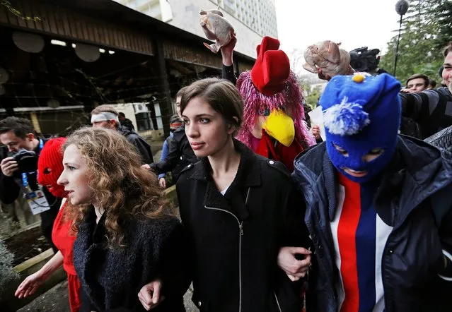 p*ssy Riot members Nadezhda Tolokonnikova, center, and Maria Alekhina, left, arrive for a press conference while followed by a person in a chicken costume protesting the punk group – who have feuded with Vladmir Putin's government for years – Thursday, Feb. 20, 2014, in Sochi, Russia. (Photo by David Goldman/AP Photo)