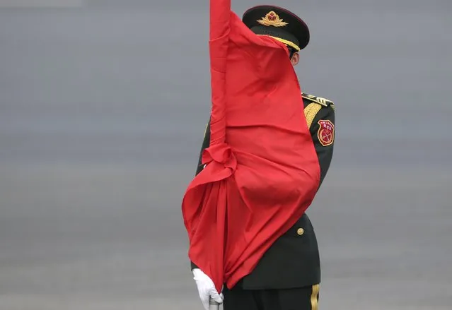A soldier from Chinese honour guards collects a red flag after a welcoming ceremony for German President Joachim Gauck at the Great Hall of the People in Beijing, China March 21, 2016. (Photo by Jason Lee/Reuters)