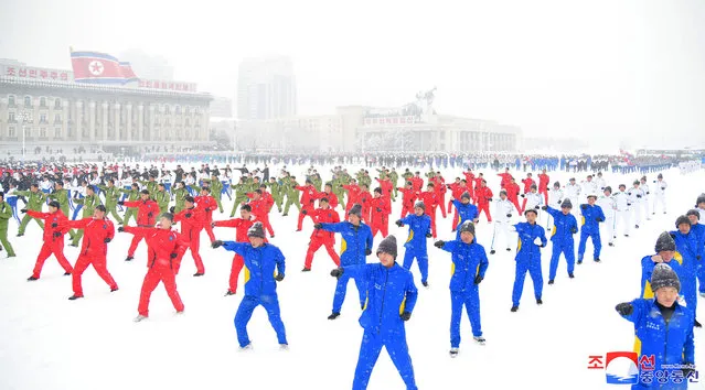This picture taken on January 14, 2024 and released from North Korea's official Korean Central News Agency (KCNA) via KNS on January 15, 2024 shows civil servants of committees, provinces, and central agencies performing in Kim Il Sung Square to mark the first sports day of the new year in the snow in Pyongyang. (Photo by KCNA via KNS/AFP Photo)