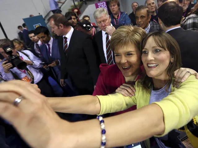 First Minister of Scotland and Scottish National Party leader Nicola Sturgeon, second right, poses for photographs at the count of Glasgow constituencies for the general election in Glasgow, Scotland, Friday, May 8, 2015. (Photo by Scott Heppell/AP Photo)