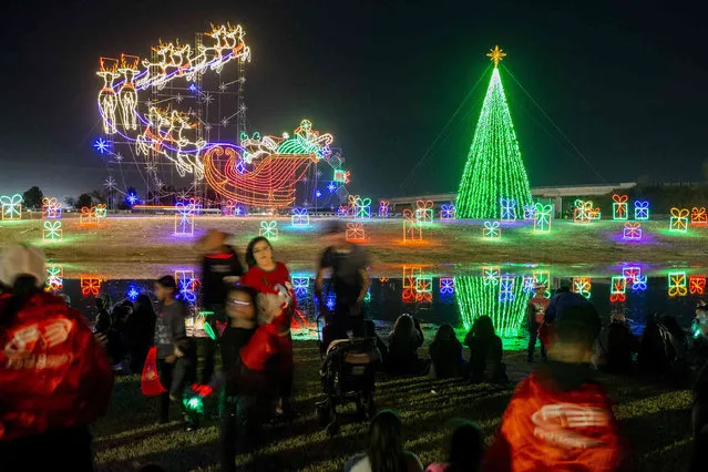 Odessans watch as the Christmas tree is lit at the opening night of Starbright Village presented by First Basin Credit Union at McKinney Park Thursday, December 2, 2021, in Odessa, Texas. Starbright Village's lighting display includes over 300,000 lights and feature 80-plus lighted displays. (Photo by Jacob Ford/Odessa American via AP Photo)