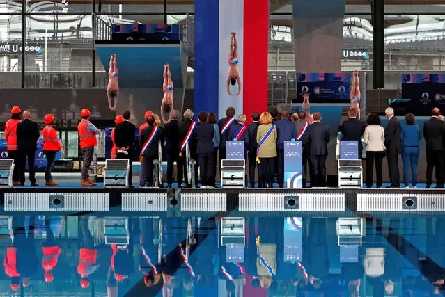 French President Emmanuel Macron, officials and workers look at a diving performance during the inauguration of the Olympic Aquatics Centre (CAO), a multifunctional venue for the 2024 Paris Olympic Games construction site which is under the management of the “Metropole Grand Paris” in Saint-Denis, near Paris, France on April 4, 2024. (Photo by Gonzalo Fuentes/Reuters)