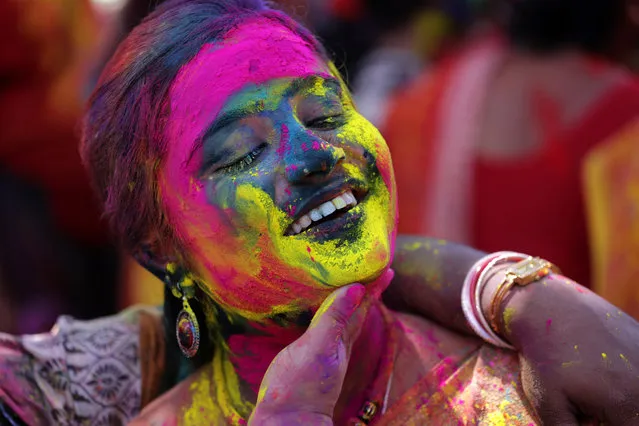 Indian women apply colored powder on each other as they celebrate the Holi festival in Bardwan, west of Calcutta,  eastern India, 16 March 2014. Holi is the Hindu spring festival of colors. (Photo by Piyal Adhikary/EPA)