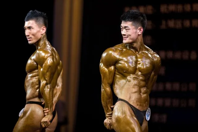This photo taken on April 9, 2016 shows competitors posing during a bodybuilding competition in Hangzhou, eastern China's Zhejiang province. (Photo by AFP Photo/Stringer)