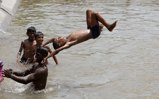 Indian children's cooldown to beat the scorching heat at a canal in Jammu, the winter capital of Kashmir, India, 06 June 2019. The region is witnessing intense heat wave conditions with peak temperature cross the 44 degrees Celsius. (Photo by Jaipal Singh/EPA/EFE/Rex Features/Shutterstock)