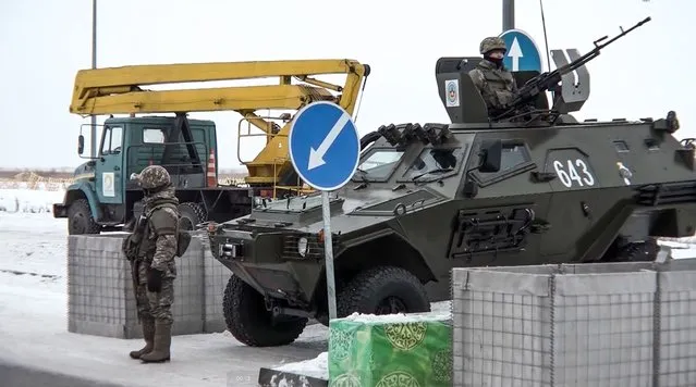 In this image taken from footage provided by the RU-RTR Russian television, A Kazakhstan's soldier stands next to a military vehicle at a check point in Kazakhstan, Friday, January 7, 2022. Over 70 cargo planes are being deployed in Russia's peacekeeping mission in Kazakhstan according to the Defense Ministry chief spokesman's briefing on Friday, after the worst street protests since the country gained independence three decades ago. The demonstrations began over a near-doubling of prices for a type of vehicle fuel and quickly spread across the country, reflecting wider discontent over the rule of the same party since independence.  (Photo by RU-RTR Russian Television via AP Photo)