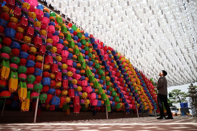 A man looks at lotus lanterns attached to prayer petitions at Jogye temple in Seoul, South Korea, on May 8, 2024. (Photo by Kim Hong-Ji/Reuters)