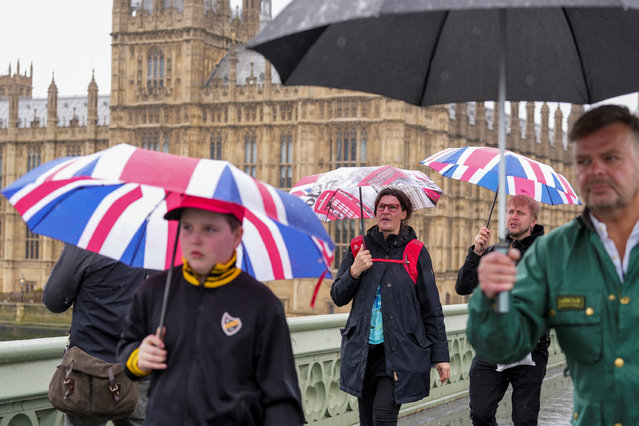 Pedestrians carrying umbrellas cross Westminster Bridge, in London, Britain, on April 28, 2024. (Photo by Maja Smiejkowska/Reuters)