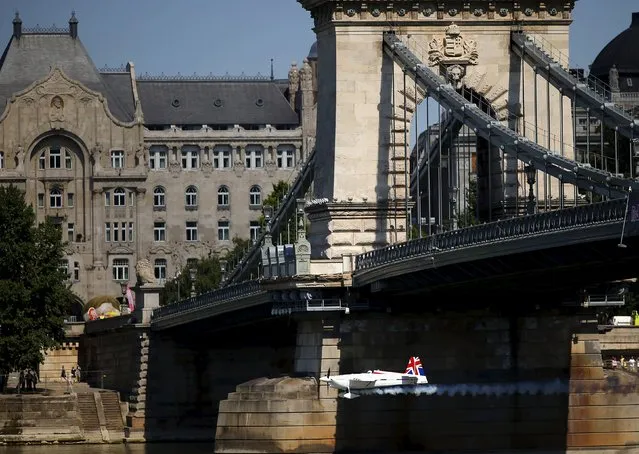 British pilot Paul Bonhomme flies under a chain bridge with his Edge 540 V2 during the practice session  at the Red Bull Air Race World Championship in Budapest, Hungary July 3, 2015. (Photo by Laszlo Balogh/Reuters)