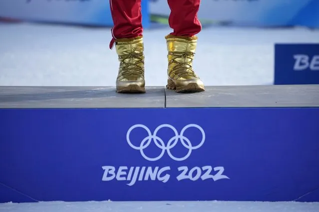 Gold medal finisher Russian athlete Alexander Bolshunov wears gold boots during a venue ceremony after the men's weather-shortened 50km mass start free cross-country skiing competition at the 2022 Winter Olympics, Saturday, February 19, 2022, in Zhangjiakou, China. (Photo by Aaron Favila/AP Photo)