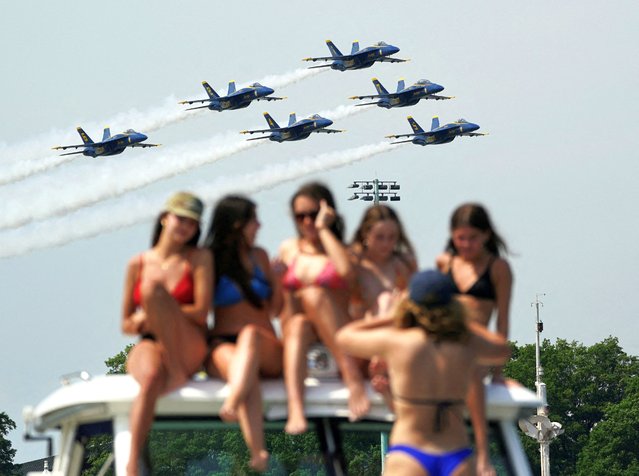 Women atop a boat take a group photo as the U.S. Navy’s Flight Demonstration Squadron’s Blue Angels perform in the skies over Annapolis, Maryland, on May 22, 2024. (Photo by Kevin Lamarque/Reuters)