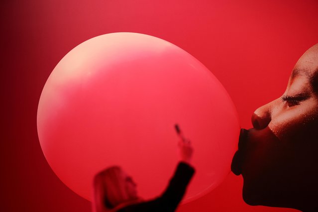 A woman holds up an electric device, during the GSMA's 2023 Mobile World Congress (MWC) in Barcelona, Spain on March 1, 2023. (Photo by Nacho Doce/Reuters)