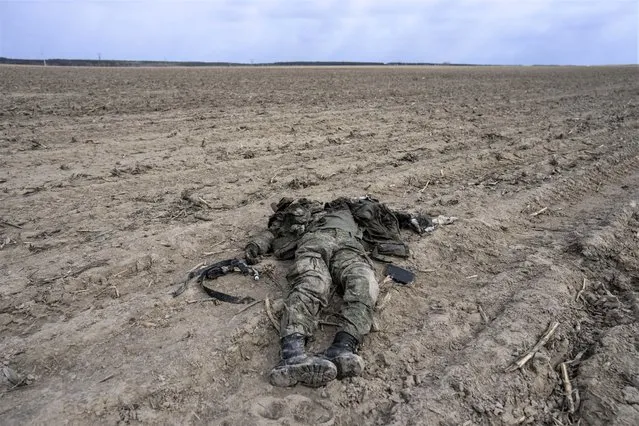 A Russian soldier killed during combats against the Ukrainian army lies in a corn field in Sytnyaky on the outskirts of Kyiv, Ukraine, Sunday, March 27, 2022. (Photo by Rodrigo Abd/AP Photo)