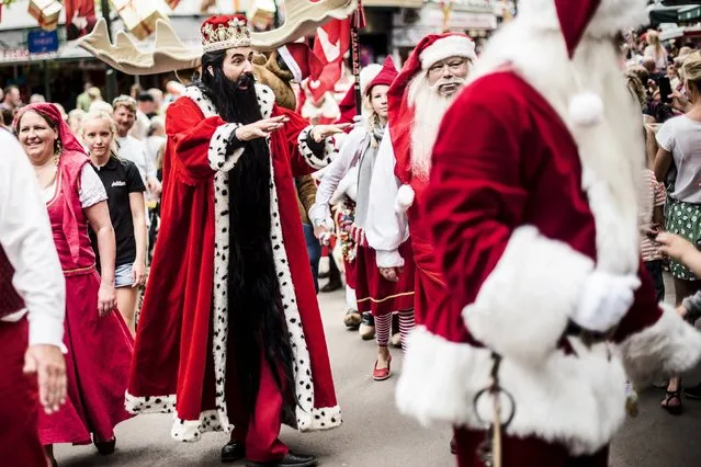 Participants are seen at the World Santa Claus Congress in Copenhagen, Denmark, July 22, 2015. Drawing Santas from around the world, the three-day event in the Danish capital hosts a range of activities including parades, a Santa Obstacle Course and shows at the Bakken amusement park. The World Santa Claus Congress dates back from 1957 when its founder, Bakken entertainer Professor Tribini, decided to bring Santas together for some summer festive fun. (Photo by Sophia Juliane Lydolph/Reuters/Scanpix Denmark)