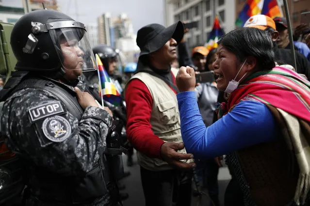 A supporter of Bolivia's former President Evo Morales yells at a police officer, telling him to respect the nation's indigenous people in La Paz, Bolivia, Tuesday, November 12, 2019. Former President Evo Morales, who transformed Bolivia as its first indigenous president, flew to exile in Mexico on Tuesday after weeks of violent protests, leaving behind a confused power vacuum in the Andean nation. (Photo by Natacha Pisarenko/AP Photo)