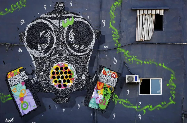 A mural painting by the Lebanese steet artists group Ashekman covers the wall of a building in the highly polluted area of Karantina on the outskirts of the capital Beirut on October 7, 2019. Greenpeace MENA collaborated with Ashekman, to create a mural the mural painting in order to grab attention on the issue of air pollution. (Photo by Joseph Eid/AFP Photo)