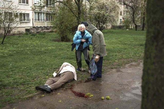 A woman cries next to the body of her father lying on the ground after a Russian attack in Kharkiv, Ukraine, Monday, April 18, 2022. (Photo by Felipe Dana/AP Photo)