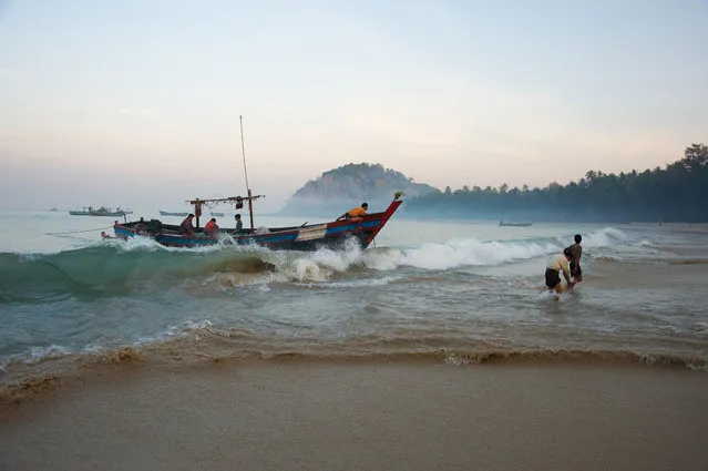 “Dawn landing”. After a night out at sea fishing for squid the fishermen return to Ngapali beach at dawn with their catch. Photo location: Ngapali Beach, Myanmar. (Photo and caption by Malcolm McDougall/National Geographic Photo Contest)