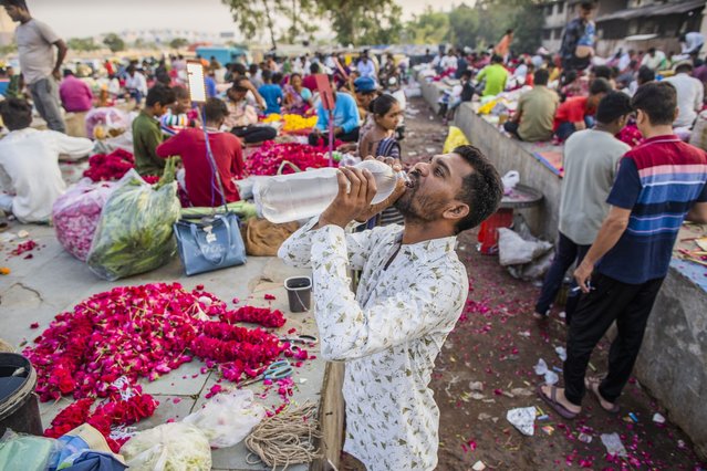 A vendor takes a water break at a wholesale flower market in Ahmedabad in Gujarat, India, on Friday, May 5, 2023. Ahmedabad is an example of the patchwork coping mechanisms that cities around the world are taking to save lives in a hotter world. (Photo by Prashanth Vishwanathan/Bloomberg)