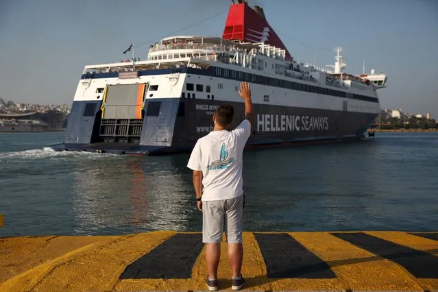 A man waves goodbye as a ship departs from the port of Piraeus, Greece August 2, 2015. Despite its economic and political troubles, Greece remains a popular summer tourist destination. (Photo by Yiannis Kourtoglou/Reuters)
