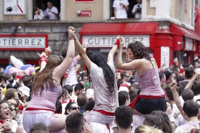 Revellers celebrate moments before the rocket fire or “Txupinazo” marks the start of the Festival of San Fermin (or Sanfermines) at Consistorio square in Pamplona, Spain, 06 July 2014. (Photo by Javier Lizin/EFE)