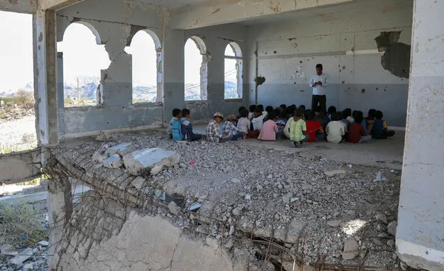Yemeni children attend class on the first day of the new academic year in the country's third-city of Taez on September 3, 2019, at a school that was damaged last year in an air strike during fighting between the Saudi-backed government forces and the Huthi rebels. (Photo by Ahmad Al-Basha/AFP Photo)
