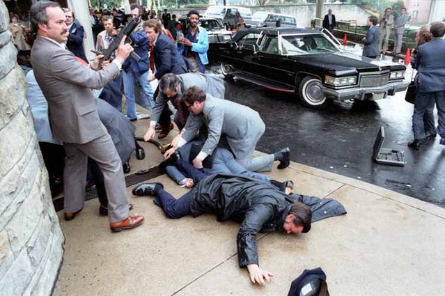 White House Press Secretary James Brady and District of Columbia police officer Thomas Delahanty lie wounded on the ground after John Hinckley Jr. fired six shots at President Reagan outside the Washington Hilton Hotel in Washington, DC, on March 30, 1981. (Photo by Courtesy Reagan Library via Reuters)