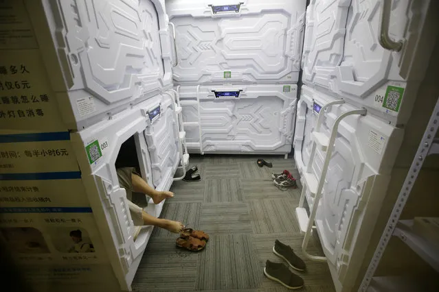 An IT employee takes off shoes as he prepares to sleep in a capsule bed unit at Xiangshui Space during lunch break in Beijing's Zhongguancun area, China July 11, 2017. (Photo by Jason Lee/Reuters)