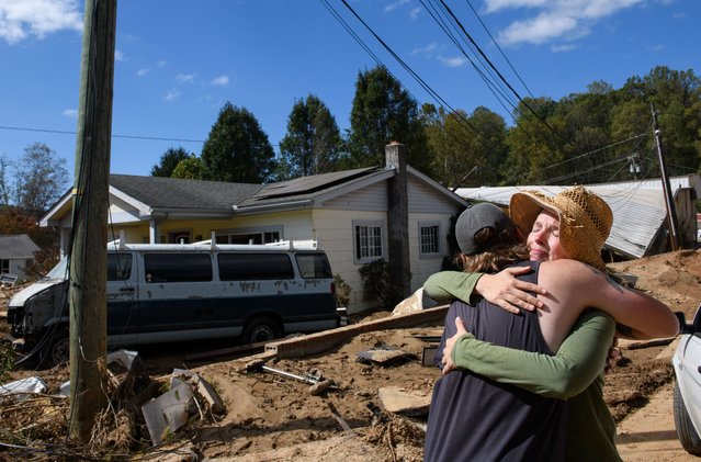 Emily Ogburn, right, hugs her friend Cody Klein after he brought her a meal on October 2, 2024 in Swannanoa, North Carolina. Ogburn's home was spared and she spent the morning of the storm helping and comforting neighbors who had found shelter on a neighbors porch. According to reports, at least 160 people have been killed across the southeastern U.S., and more than a million are without power due to the storm. The White House has approved disaster declarations in multiple southern states, freeing up federal emergency management money and resources. (Photo by Melissa Sue Gerrits/Getty Images)