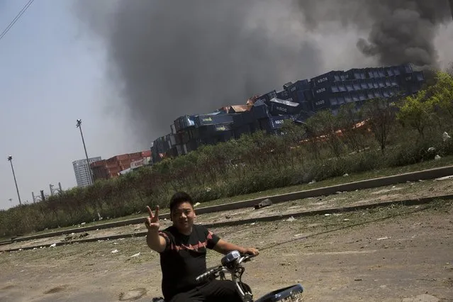 A man shows the victory sign at the explosion site in Binhai new district in Tianjin, China August 13, 2015. (Photo by Damir Sagolj/Reuters)