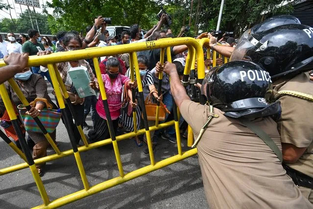 Activists from Samagi Vanitha Balawegaya, a part of the main opposition party Samagi Jana Balawegaya try to overturn a police barricade during a protest outside Sri Lanka's Prime Minister Ranil Wickremesinghe's private residence, amid the country's economic crisis, in Colombo on June 22, 2022. (Photo by Ishara S. Kodikara/AFP Photo)