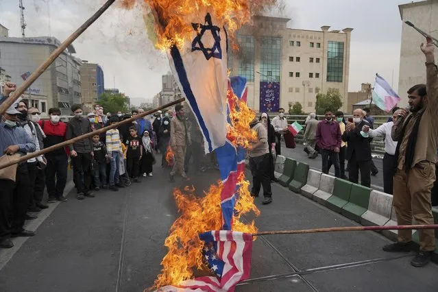Demonstrators burn representations of Israeli, British and U.S. flags during the annual pro-Palestinians Al-Quds, or Jerusalem, Day rally in Tehran, Iran, Friday, April 29, 2022. (Photo by Vahid Salemi/AP Photo)