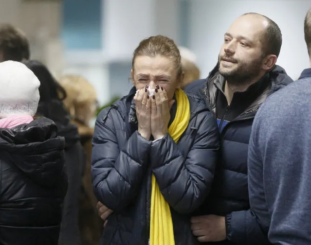 A stewardesse with Ukrainian air-line reacts, near to coffins of the flight crew members of the Ukrainian 737-800 plane that crashed on the outskirts of Tehran, during a memorial service at Borispil international airport outside Kyiv, Ukraine, Sunday, January 19, 2020. (Photo by Efrem Lukatsky/AP Photo)
