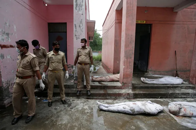 Police personnel stand next to the dead bodies of the victims of a passenger train accident, outside a mortuary in Muzaffarnagar, in the northern Indian state of Uttar Pradesh, India, August 20, 2017. (Photo by Adnan Abidi/Reuters)