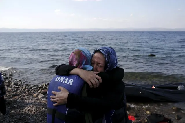 Two Afghan migrant women hug, moments after they arrived on a dinghy on the island of Lesbos, Greece August 23, 2015. (Photo by Alkis Konstantinidis/Reuters)
