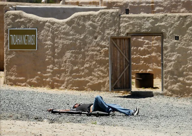 A role-playing actor lays on the ground after emerging with a weapon to fire at Canadian soldiers from the Royal 22nd Regiment during a non-combative extraction operation in a simulated village  as part of Rim of the Pacific (RIMPAC) 2016 exercise held at Camp Pendleton, California United States, July 11, 2016. (Photo by Mike Blake/Reuters)
