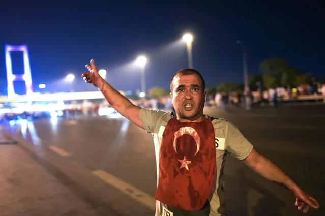A man covered with blood points at the Bosphorus bridge as Turkish military clashes with people at the entrance to the bridge in Istanbul on July 16, 2016. Turkish military forces on July 16 opened fire on crowds gathered in Istanbul following a coup attempt, causing casualties, an AFP photographer said. The soldiers opened fire on grounds around the first bridge across the Bosphorus dividing Europe and Asia, said the photographer, who saw wounded people being taken to ambulances. (Photo by Bulent Kilic/AFP Photo)