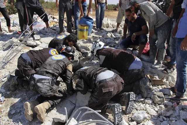 This photo provided by the Syrian Civil Defense White Helmets, which has been authenticated based on its contents and other AP reporting, shows civil defense workers searching in the rubble after airstrikes hit in Khan Sheikhoun, in the northern province of Idlib, Syria, Sunday, September 24, 2017. A Syrian war monitoring group says airstrikes have targeted rural Aleppo for the first time in months since a cease-fire took hold in the province. (Photo by Syrian Civil Defense White Helmets via AP Photo)