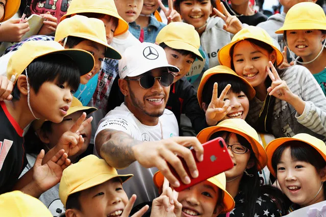 Lewis Hamilton of Great Britain and Mercedes GP poses for a photo with young fans at the circuit during previews ahead of the Formula One Grand Prix of Japan at Suzuka Circuit on October 5, 2017 in Suzuka. (Photo by Mark Thompson/Getty Images)