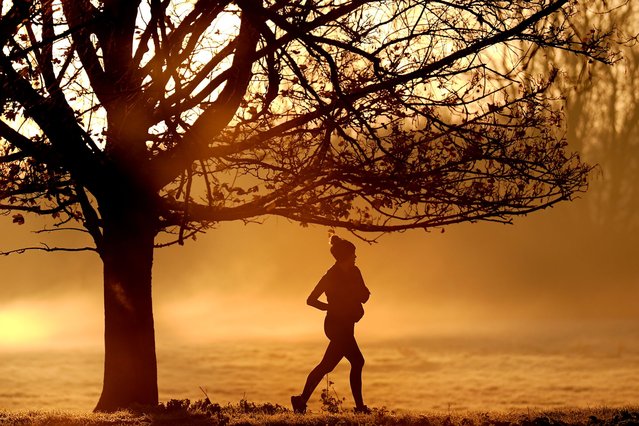 A woman runs along the banks of the River Cam in Cambridge at sunrise on Thursday, November 28, 2024. Clearer weather is forecast for the UK today as Storm Conall moves on to the Netherlands. (Photo by Joe Giddens/PA Images via Getty Images)
