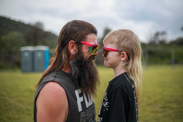 Dan Prior and his son Hunter Prior pose for a photograph at the Mulletfest 2023 Grand Final at Hebburn Motorsport Park on December 02, 2023 in the Hunter Valley, Australia. Mulletfest is an event that honours the best “mullet” haircuts in various styles and categories, including “everyday”, “grubby”, “ranga” (red hair), “vintage”, “extreme”, “international” and “junior”. This year’s “head to head” battle for the best mullet haircut attracted contestants from all over Australia, and one finalist from the UK. The competition began in the Hunter Valley town of Kurri Kurri in 2018 as an effort to save a family pub during an economic downturn. It drew international attention for its celebration of the unique hairstyle. The festival is now held annually to raise funds for brain cancer research.. (Photo by Roni Bintang/Getty Images)