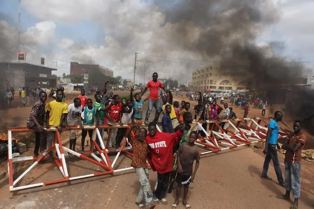 Anti-coup protesters gather at a barricade they set up in Ouagadougou, Burkina Faso, September 19, 2015. (Photo by Joe Penney/Reuters)