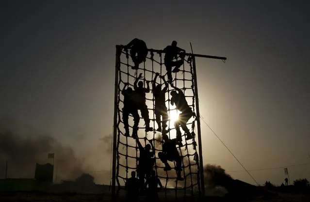 Palestinian militants from al-Husine brigade loyal to Fatah movement, climb a net during a military-style exercise graduation ceremony in Khan Younis in the southern Gaza Strip, September 20, 2015. (Photo by Suhaib Salem/Reuters)