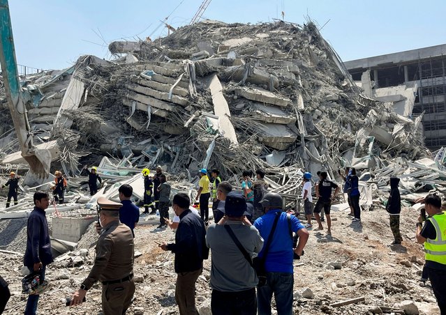 People stand near the site of a collapsed building after a strong earthquake struck central Myanmar on Friday, earthquake monitoring services said, which affected Bangkok as well with hundreds of people pouring out of buildings in the Thai capital in panic after the tremors, in Bangkok, Thailand, on March 28, 2025. (Photo by Ann Wang/Reuters)